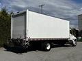 A 2021 Hino 338 box truck with a white cargo area and a grey chassis parked with its rear visible
