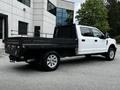A 2020 Ford F-350 SD with a flatbed configuration parked at an industrial location