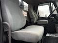 Interior of a 2019 Freightliner M2 featuring two grey cloth seats with a first aid kit mounted on the wall and a dashboard visible on the right side