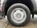 Close-up of a wheel from a 2021 Ford F600 featuring a silver rim and a black tire with tread patterns visible