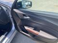 A 2017 Acura TLX car door open showing the interior door panel with wooden accents and control buttons for windows and locks