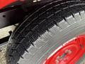 A close-up of a 2001 Toyota Dyna tire showing a detailed tread pattern and a red wheel rim