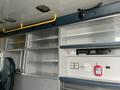 A 2016 Chevrolet Express interior showing cabinets shelves a control panel and a driver's seat