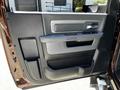 A close-up view of the door panel of a 2015 RAM 5500 featuring a textured surface a grab handle and controls for windows and locks