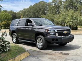 A 2017 Chevrolet Tahoe in dark gray with a distinctive front grille and chrome accents parked at an angle with a clear view of its front and side features