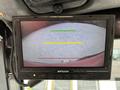 A display monitor showing a view of a Toro Groundsmaster with colored guide lines indicating distance and positioning