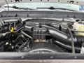 Engine compartment of a 2015 Ford F-350 SD featuring a large black plastic intake manifold and various hoses and electrical connections