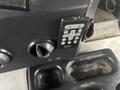 A close-up of the control panel of a 2012 Workhorse W62 featuring buttons for radio volume and tuning alongside two circular vents.