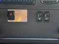 A control panel in a 2004 Freightliner M2 featuring a switch labeled "SYSTEM ON" and two buttons with icons for hydraulics and a trailer