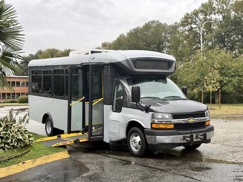 A 2020 Chevrolet Express bus with a low entrance ramp extended is parked with its doors open