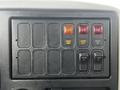 A control panel with multiple switches and buttons including labels for send warn cut out and boom up