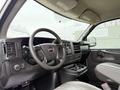 Interior view of a 2014 GMC Savana showing the steering wheel dashboard and front seat with cup holders