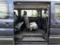 Interior view of a 2020 Ford Transit showing rows of black leather seats with ample space between them