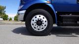 Side view of a blue 2012 International DuraStar 4300 truck wheel showcasing a silver rim with multiple lug nuts and a black tire mounted on it