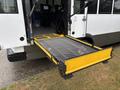 A 2020 Chevrolet Express with a deployed wheelchair lift featuring a metal mesh platform and yellow edges