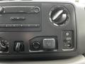 Dashboard control panel of a 2013 Ford Econoline showing audio controls air conditioning settings and a power outlet