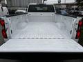 The bed of a 2021 Chevrolet Silverado 3500HD showcasing a clean and spacious white interior with defined wheel wells and textured flooring