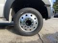 Close-up of a chrome wheel on a 2013 Ford F-450 SD showing six large lug nuts and a thick black tire with visible tread patterns