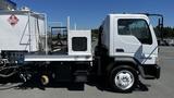 A white 2006 Ford LCF 550 truck featuring a flatbed design with equipment mounted on the rear and a visible hydraulic system on the side