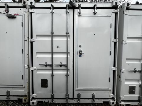 A 40 foot custom climate controlled storage container with a lockable door and multiple latches on the front surface