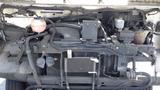 View of the engine compartment of a 2011 Ford Econoline showing various components including hoses and cooling systems