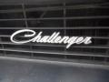 A close-up of the chrome "Challenger" emblem on the front grille of a 1974 Dodge Challenger
