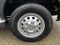 Close-up of a silver wheel with a six-bolt pattern mounted on a black tire showcasing its tread design