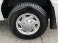 A close-up of a silver wheel from a 2011 Ford Econoline featuring a five-spoke design and a black tire labeled AGILIS CROSSCLIMATE 225/75 R16