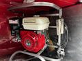 A red Honda GX160 engine mounted on metal brackets with a large fan behind it designed for use in a firefighting apparatus