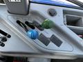 Control levers of a 2018 New Holland Boomer 45 tractor with blue green and black handles arranged in a row on a gray panel