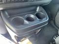 A black plastic cup holder with three openings located in the front interior of a 2012 Chevrolet Express
