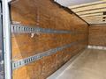 A 2017 Hino 338 box truck interior featuring wooden walls with metal tracks for cargo securing and a smooth metal floor