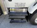 A 2009 International 7500 truck showing a metallic step with a perforated surface and an air tank mounted beside it