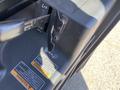 Close-up of a 2018 Kubota RTV-X 1100 C vehicle's latch mechanism and warning label on the side panel