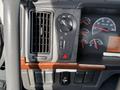 The dashboard controls of a 2005 Volvo VND showing air conditioning settings a hazard light button and various gauge displays