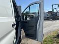 A 2016 Ford Transit van with the driver's side door open showcasing the interior features and layout