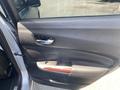 A 2017 Acura TLX car door interior featuring a handle and armrest with wood accents