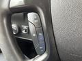 Close-up of the steering wheel controls of a 2016 Chevrolet Express including buttons for cruise control and adjustments