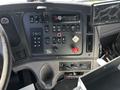 The interior dashboard of a 2012 Freightliner M2 112 with various controls buttons gauges and a mounted GPS device