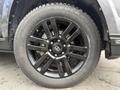 A close-up of a black alloy wheel from a 2021 Toyota 4Runner featuring a multi-spoke design and a Toyo Geolandar tire