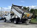 A 2012 Dodge Ram 5500 dump truck with a raised bed and a metal dumping mechanism visible on the back