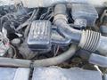 A dirty engine compartment of a 2013 Ford Expedition showing the air intake system and various engine components