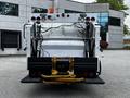 2014 Hino 195 rear view with a white body black bumpers and yellow lift arms for towing or carrying equipment