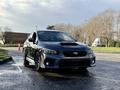A 2021 Subaru WRX in black with a prominent hood scoop and sporty design features, showcasing a sleek front grille and aggressive stance