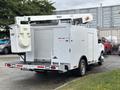 A 2017 Ford Econoline vehicle designed for utility work with a bucket lift and a white service box featuring shutter doors