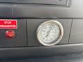 A pressure gauge displaying measurements in psi and Pa mounted on a black dashboard with a red indicator light and a stop requested sign
