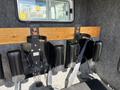 Interior view of a 1994 Volvo FE 42 showing two black seating positions with safety belts attached to a wooden wall panel