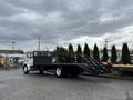 A 2008 Sterling Acterra flatbed truck with ramps and a partially loaded palm tree on the bed