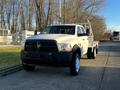 A 2014 RAM 5500 truck with a flatbed in the foreground featuring a white body and black grille