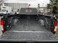 Black pickup truck bed of a 2020 RAM 3500 with a durable bed liner and storage compartments on each side